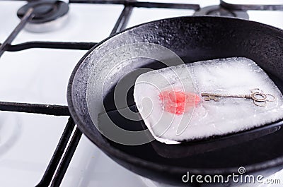 Frozen heart in a block of ice in the pan Stock Photo