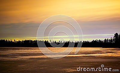 Frozen lake at night with sunset and orange colored sky and ice Stock Photo