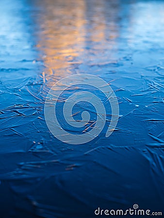 A frozen lake and reflections on the surface. Mountains during dawn. Abstract background. Detail in nature. Stock Photo