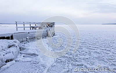 Frozen pier next to wintry lake Stock Photo