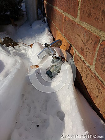 Frozen Pipes, Faucet Buried in Snow Stock Photo