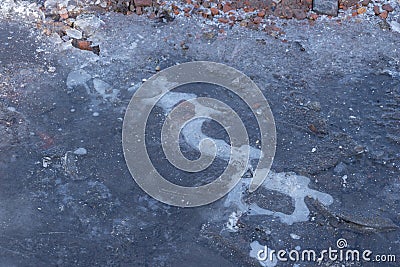 Frozen Puddle with broken ice. Ice Crust On Frozen Puddle. Winter background. Frozen puddle on the road. In January. Frozen Puddle Stock Photo