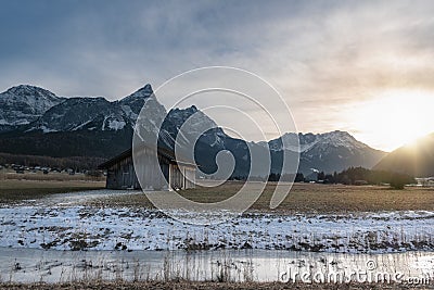 Frozen river and cottage in the Alps at sunset Stock Photo