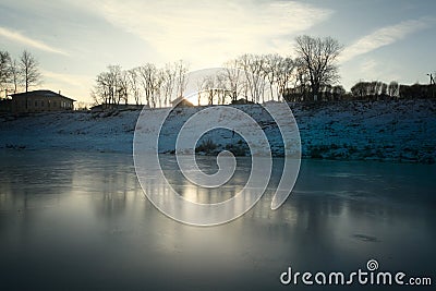 Frozen river shore small town Stock Photo