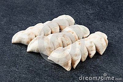 Frozen traditional russian pelmeni on gray stone table. Homemade dumplings. Semi-finished products Stock Photo