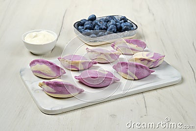 Frozen vareniki with blueberry and sour cream Stock Photo