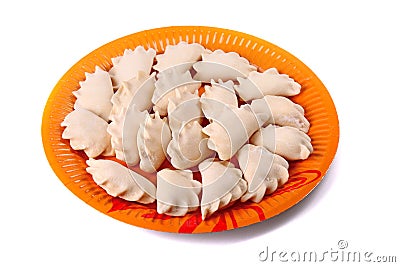 Frozen vareniki laying on the orange plate Stock Photo