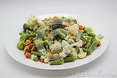 Frozen vegetables: cauliflower, green peas, leeks, broccoli, carrots, green beans on a white plate Stock Photo