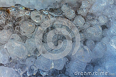 Frozen water drops with many air bubbles inside close-up. Bubble figured ice macro photography Stock Photo