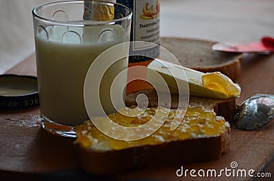 Glass of fresh milk , butter and apricot jam. Stock Photo