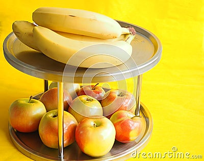 Fruit on a beautiful stand. Cool apples and bananas on a yellow background Stock Photo