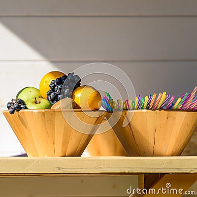 Fruit Bowl And Colorful Straws On Table Stock Photo