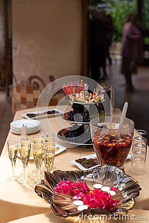 fruit bowl with fig slices, white and black grapes, a glass with lollipops, a plate with sliced smoked meats Stock Photo