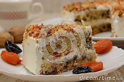 Fruit cake, a piece on a plate with dried fruits. Wood background Stock Photo