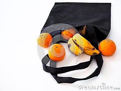 Fruit in a cloth bag with oranges and bananas isolated on white background Stock Photo