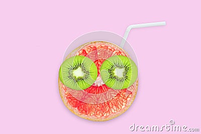 Fruit creative face with slices of grapefruit and kiwi, drinking straw on pink background, juice and summer concept Stock Photo