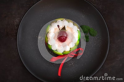 Fruit dessert tart with whipped sweet curd cream and with sweet cherry on top. Old black background. Close-up. Top view Stock Photo