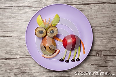 Fruit donkey on purple plate and wooden background Stock Photo