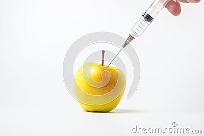 Fruit genetic modification concept. A syringe injects a chemical into an apple on a white background Stock Photo