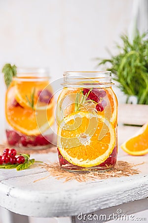 Fruit Infused Detox Water with orange red currants and rosemary Stock Photo