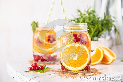 Fruit Infused Detox Water with orange red currants and rosemary Stock Photo