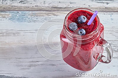 Fruit pink smoothie with berries in a glass jar on a wooden white table. Copy space Stock Photo