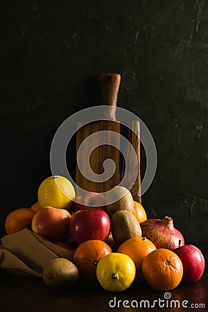 Fruit in a reusable bag. Earth day and zero waste concept. Orange, lemon, apple, kiwi, pomegranate and wooden cutting Stock Photo