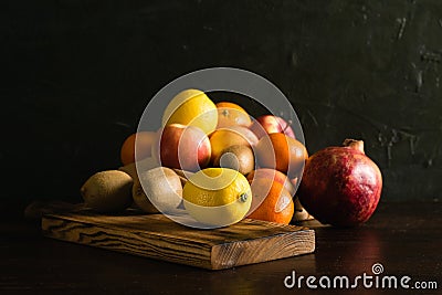 Fruit in a reusable bag. Earth day and zero waste concept. Orange, lemon, apple, kiwi, pomegranate and wooden cutting Stock Photo