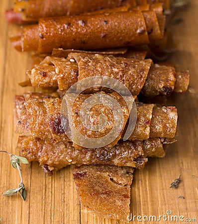 Fruit rolls on a wooden board on a black background. Useful sweets. Stock Photo