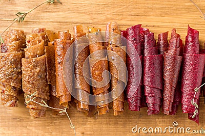 Fruit rolls on a wooden board close-up. Useful sweets for children. Stock Photo