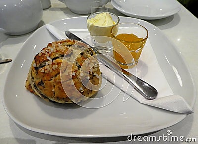 Fruit scone with jam and cream on a plate Stock Photo