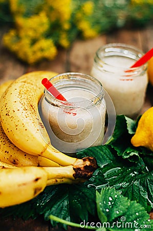 Fruit Smoothies. banana smoothies with milk. Banana Smoothie on a wooden table. Healthy breakfast: banana smoothie with oatmeal. Stock Photo