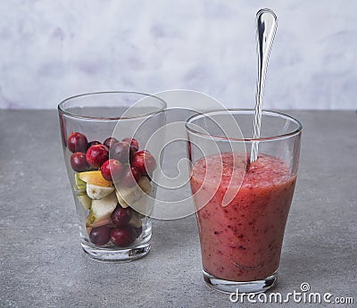 Fruit smoothies with blueberries, raspberries, apple, orange , pear and banana on gray background. Stock Photo