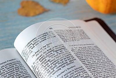 Fruit of the Spirit verses in open holy bible book with pumpkin and autumn leaves in the background Stock Photo