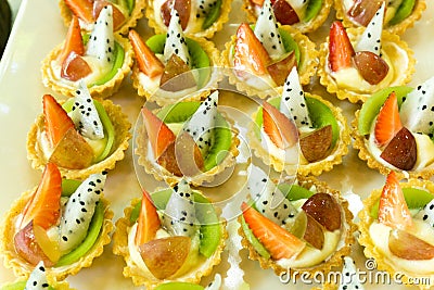 Fresh fruit pie tarts dessert tray assorted top view background. Beautiful delicious tarts, colorful pastry cakes sweets with fres Stock Photo