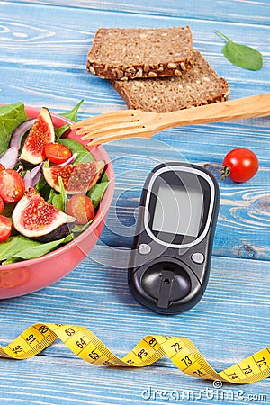 Fruit and vegetable salad and glucometer with tape measure, concept of diabetes, slimming and healthy nutrition Stock Photo