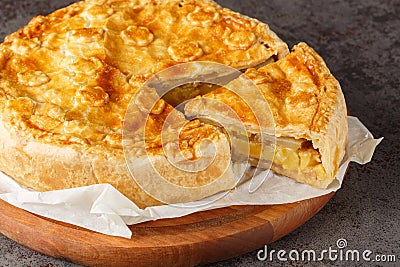Fruit and vegetable Swiss cholera pie with apple, potato, pear, onion and cheese close-up on a wooden board. Horizontal Stock Photo