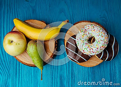 fruits lying on the table againts donuts Stock Photo