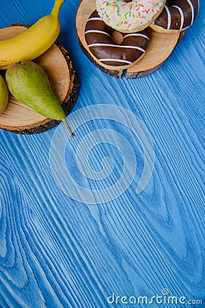 fruits lying on the table againts donuts Stock Photo