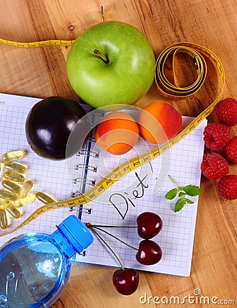 Fruits, tablets supplements and centimeter with notebook, slimming and healthy food Stock Photo