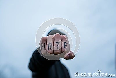 Frustrated , aggressive teenage boy showing hes fist with the word hate Stock Photo