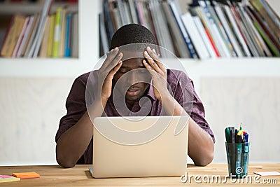 Frustrated black man feeling depressed after fail sitting with l Stock Photo