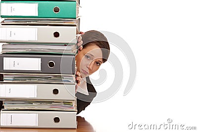 Frustrated business woman behind folder stack Stock Photo