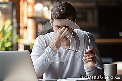 Frustrated businessman holding glasses feel eye strain, computer syndrome Stock Photo