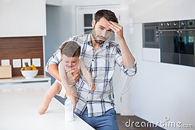 Frustrated father holding crying baby boy Stock Photo