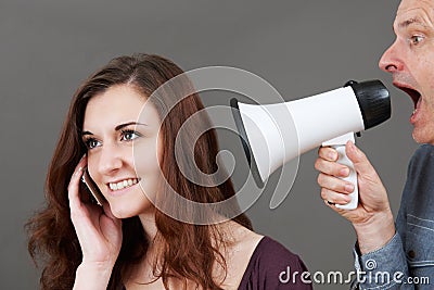 Frustrated Father Shouting At Teenage Daughter On Mobile Through Stock Photo