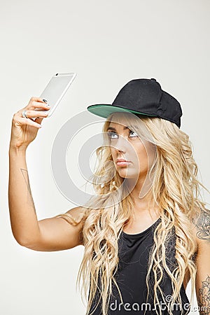 Frustrated female emotion in blonde holding phone at top over white isolated. Lack of communication or Internet. Stock Photo