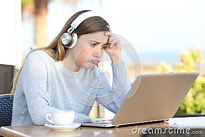 Frustrated girl checking laptop in a coffee shop terrace Stock Photo