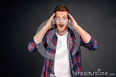 Frustrated gloomy redhead male in shirt, holding head and staring with disappointment at camera, losing bet, feeling devestation Stock Photo