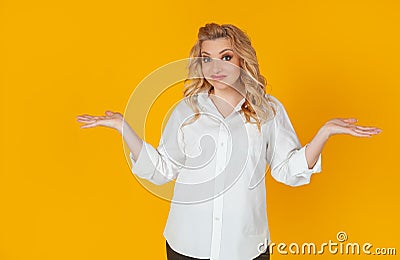 Frustrated gloomy upset confused Caucasian pretty blonde shrugs, arms outstretched, full of disbelief in doubt Stock Photo